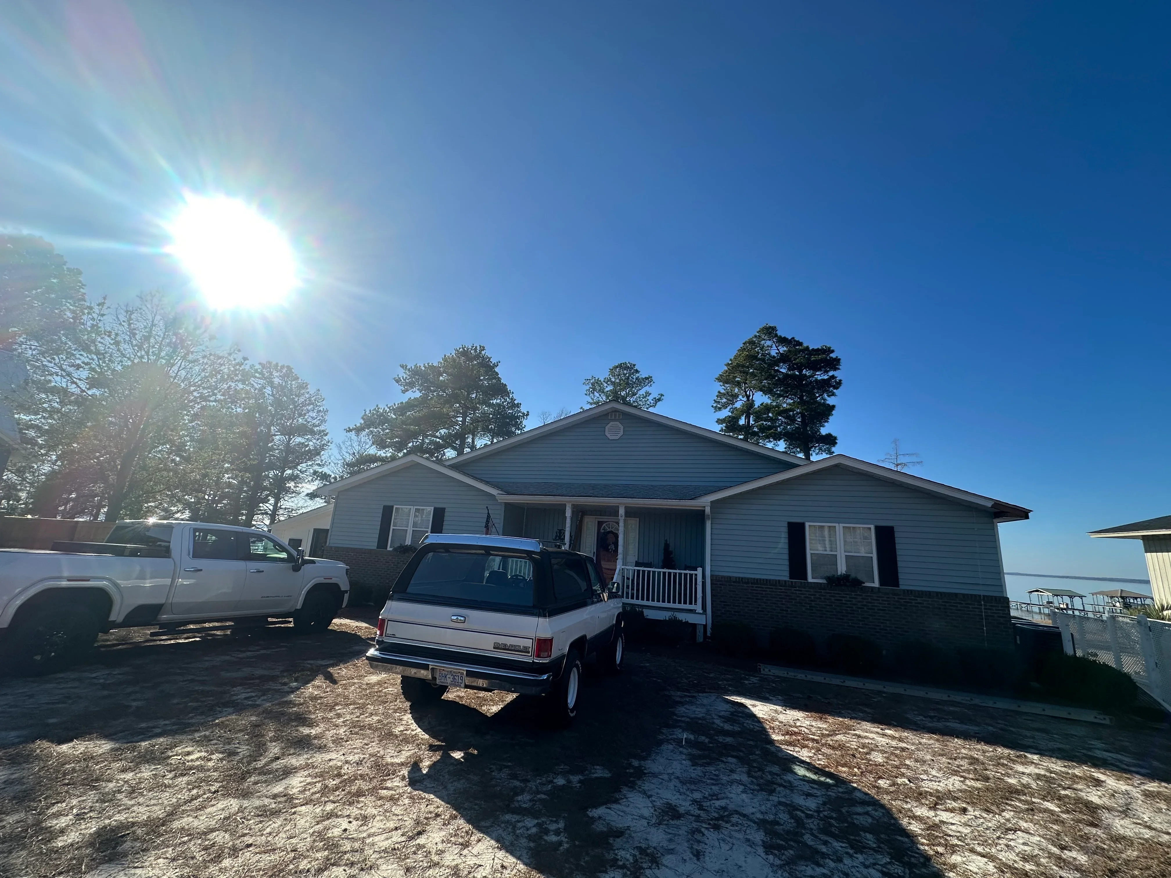 New pitched roof with gable on ranch-style home, gray shingles and metal flashing