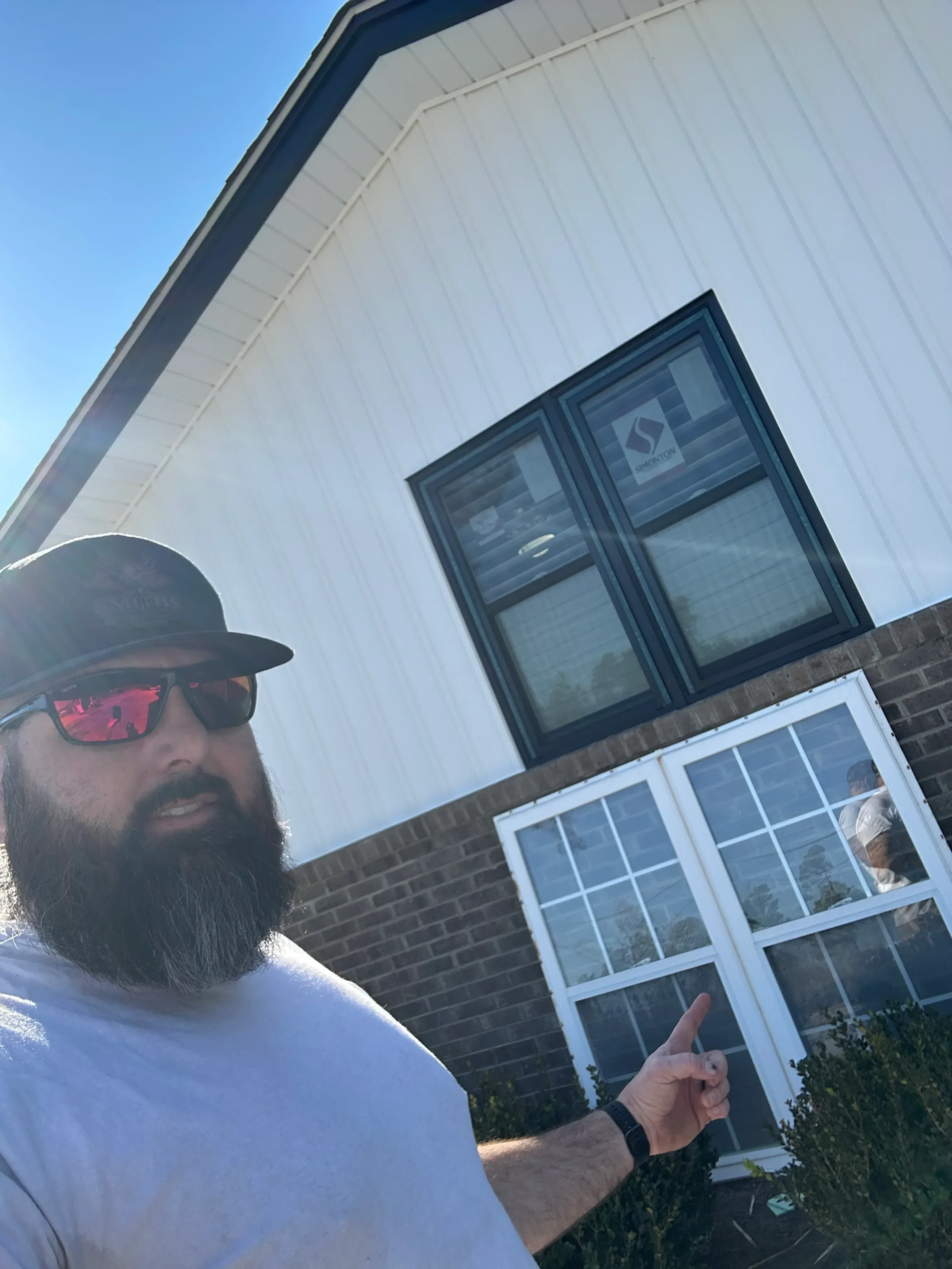 White vinyl multi-pane windows installed on brick home with white horizontal siding