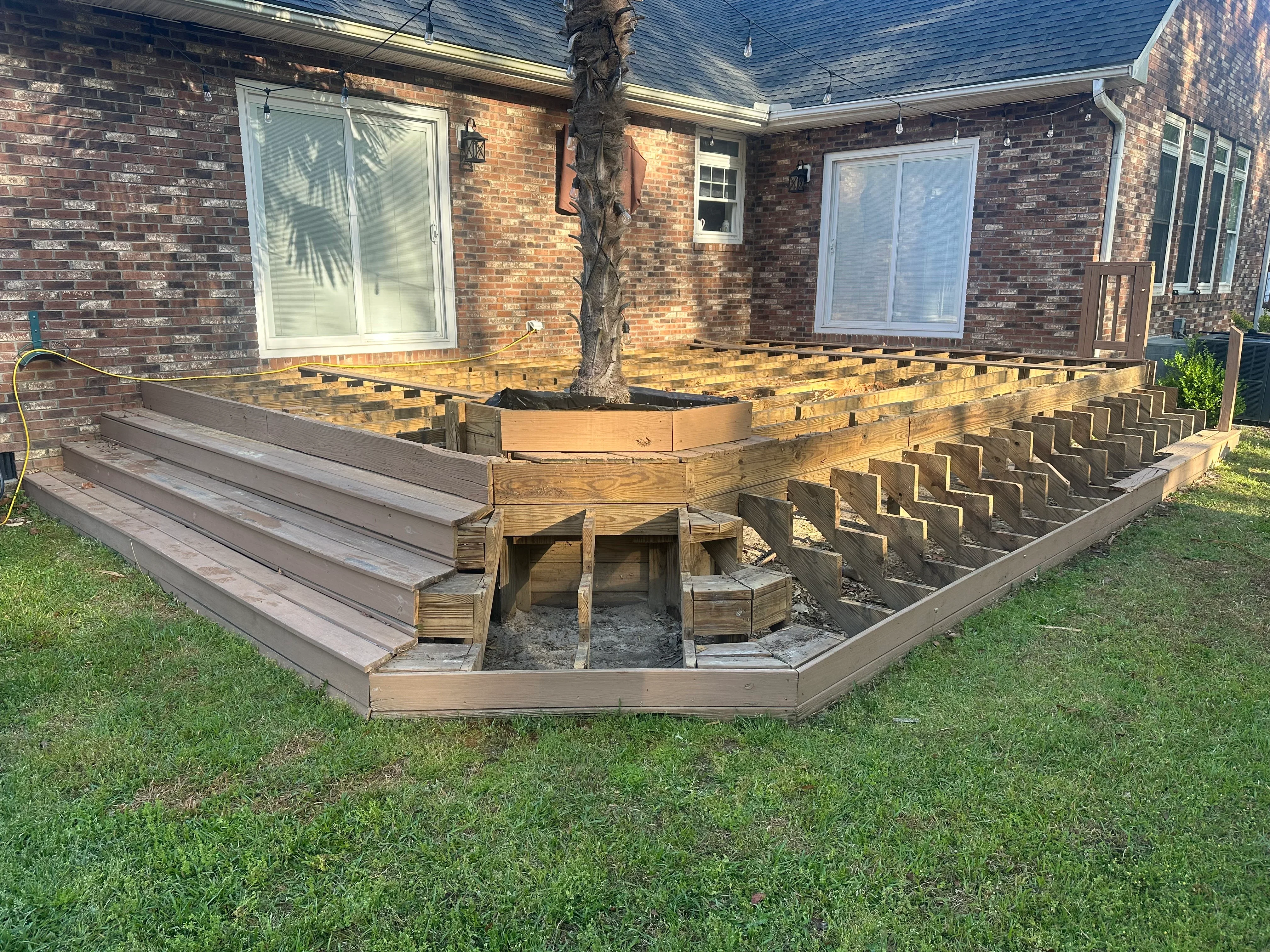 Pressure-treated wood deck framing with joists, beams, and concrete foundation supports