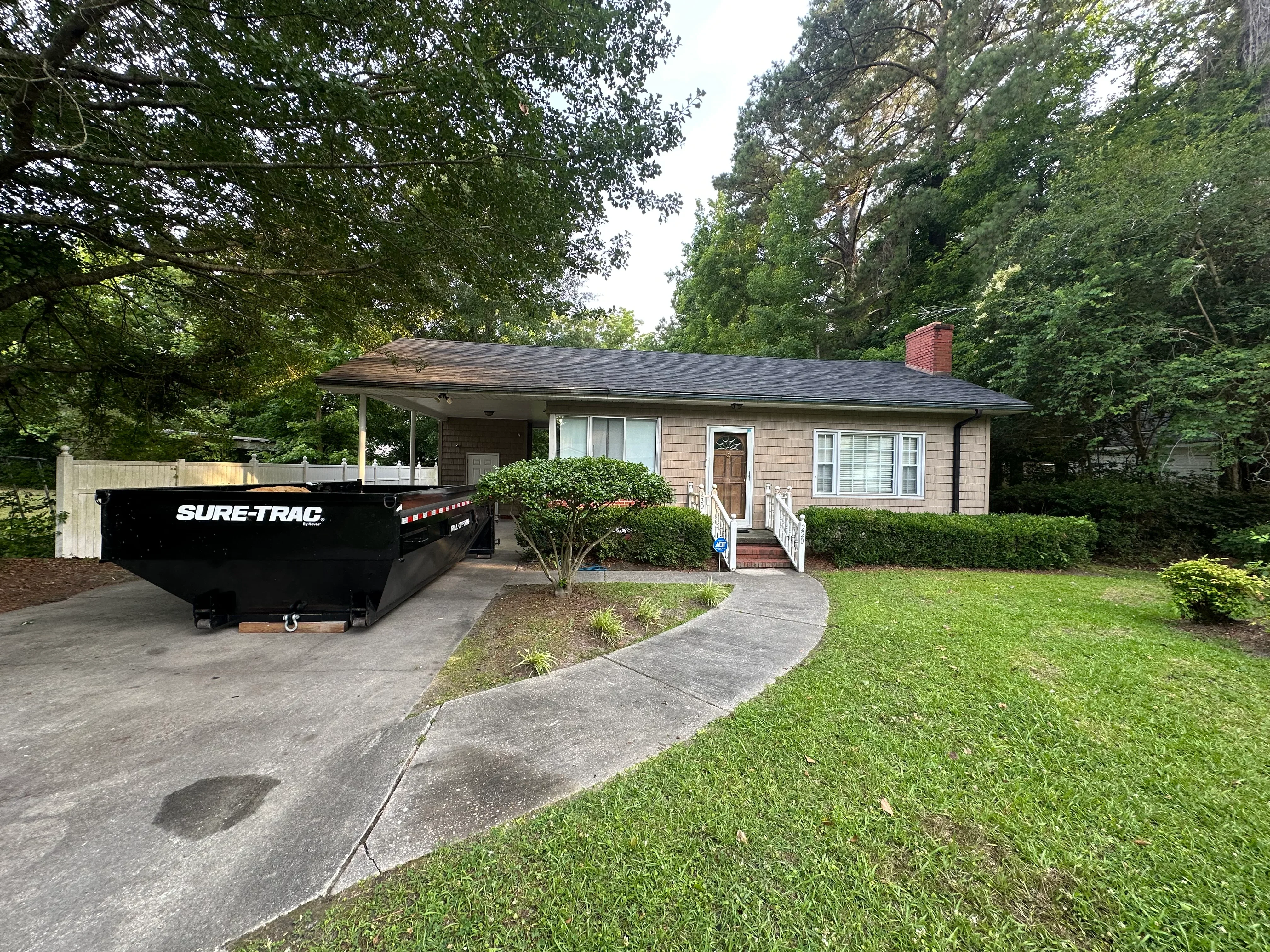 New asphalt shingle roof on brick ranch home with gray shingles and brick chimney