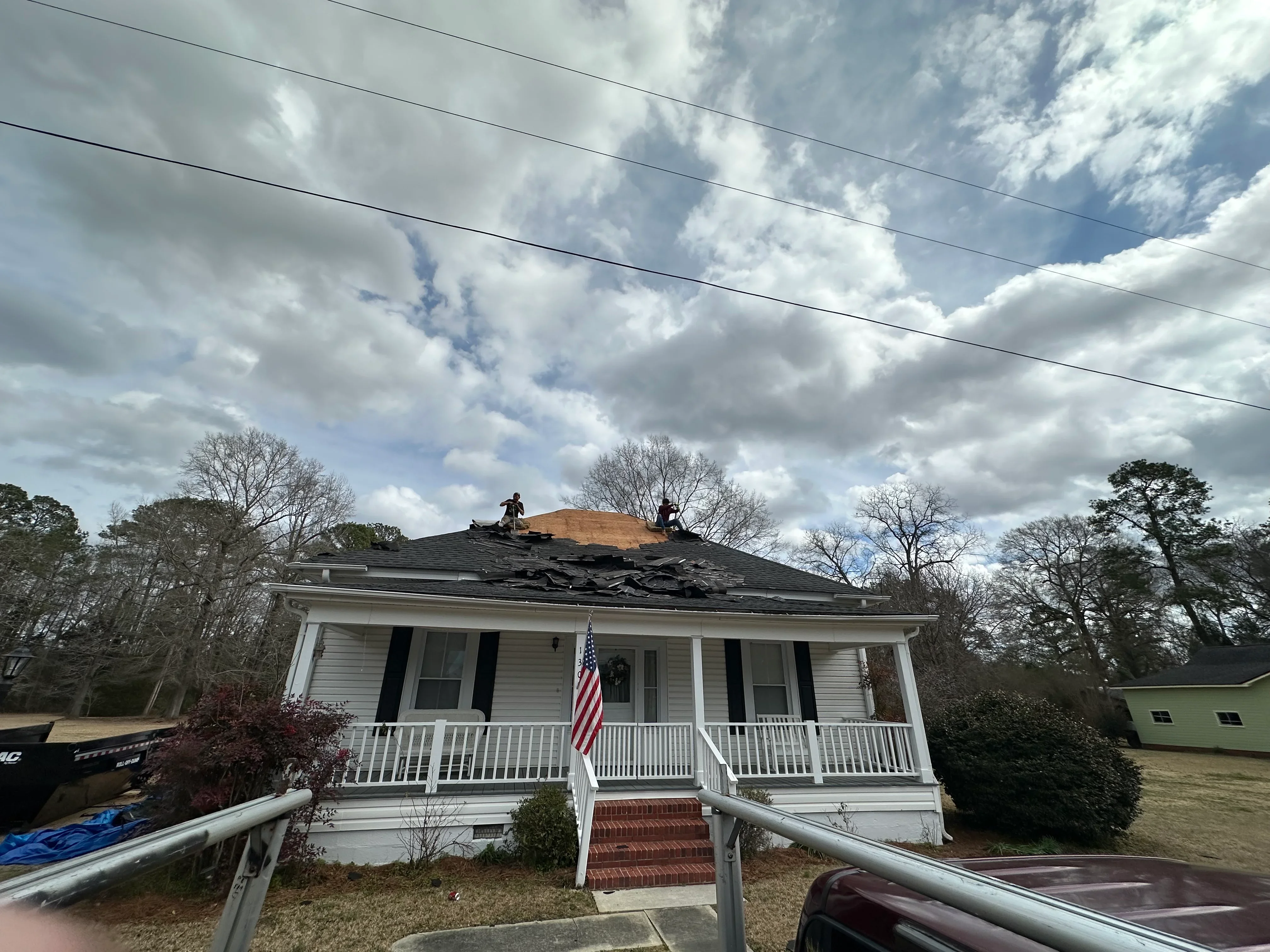 Residential roof replacement with new asphalt shingles and underlayment installation in progress